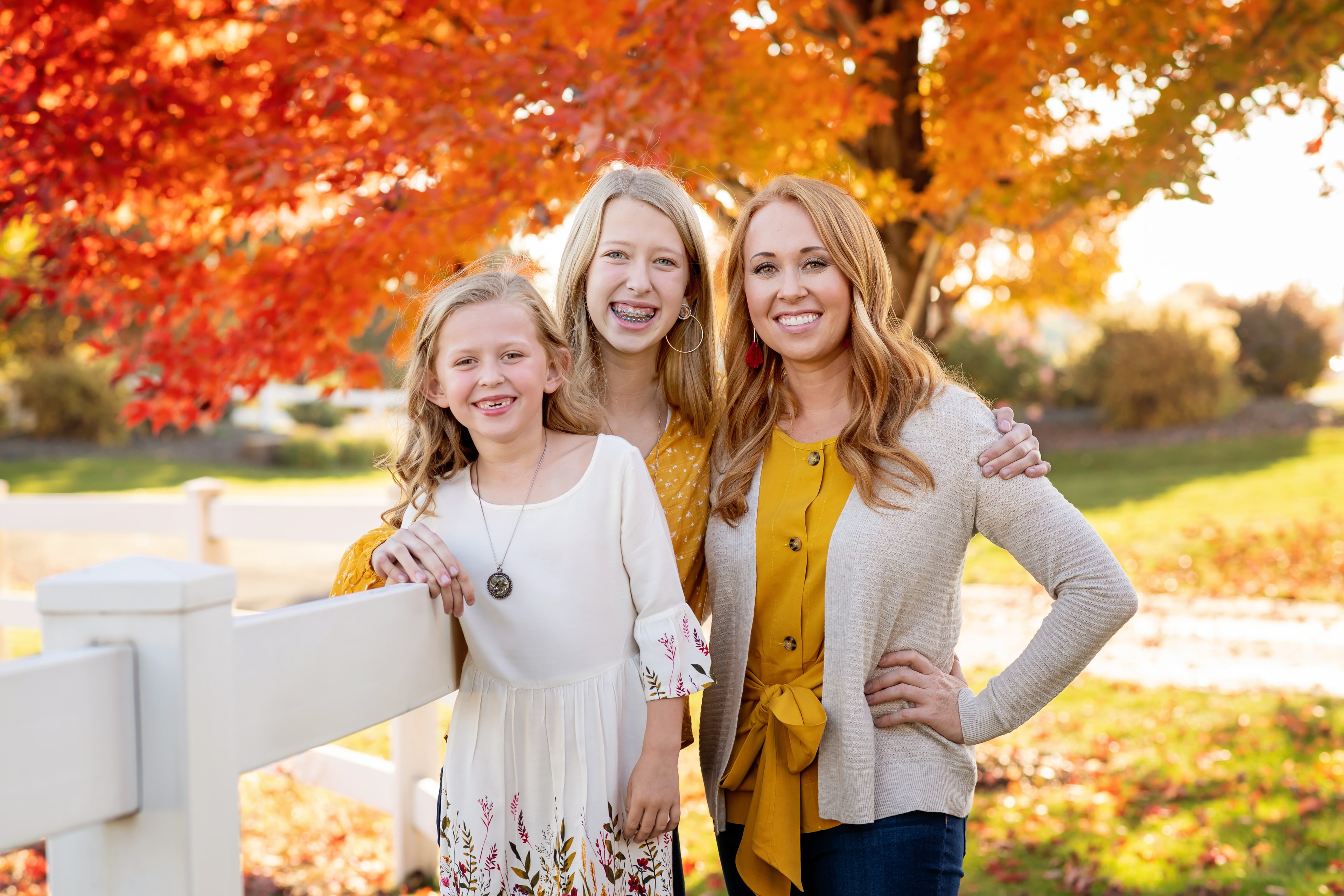Three sisters smiling in autumn foliage — Eagle Idaho family portraits