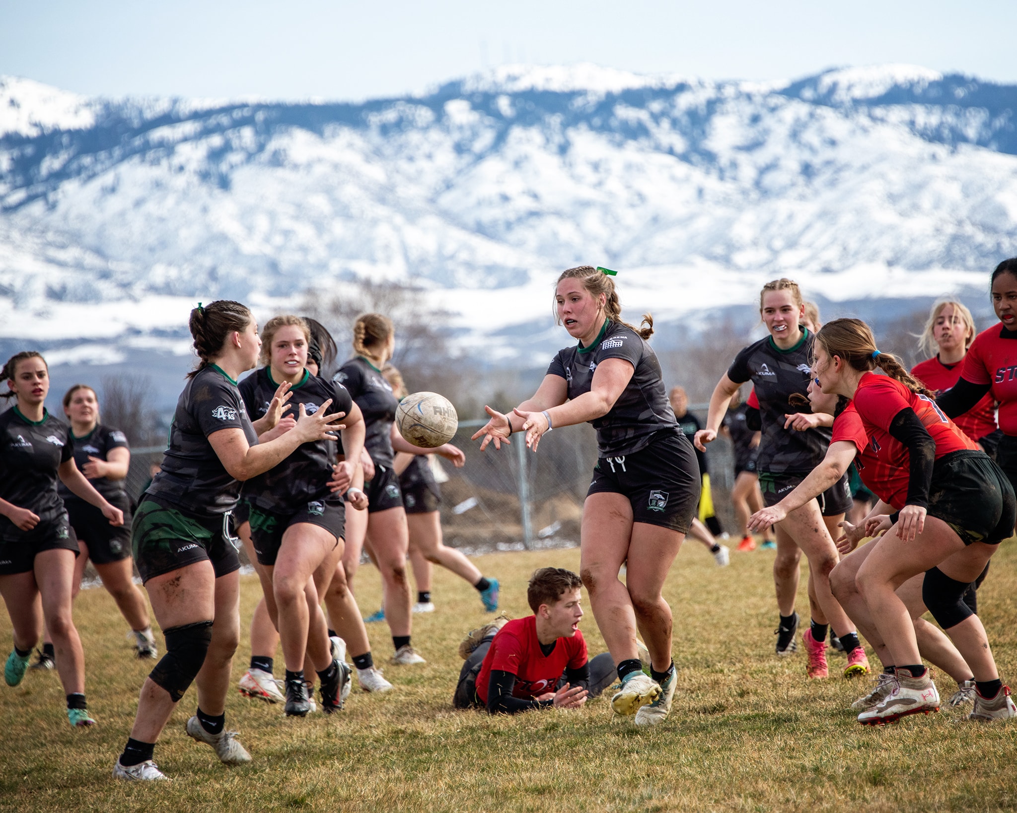 Women's rugby match with snowy mountains backdrop — Idaho sports photography