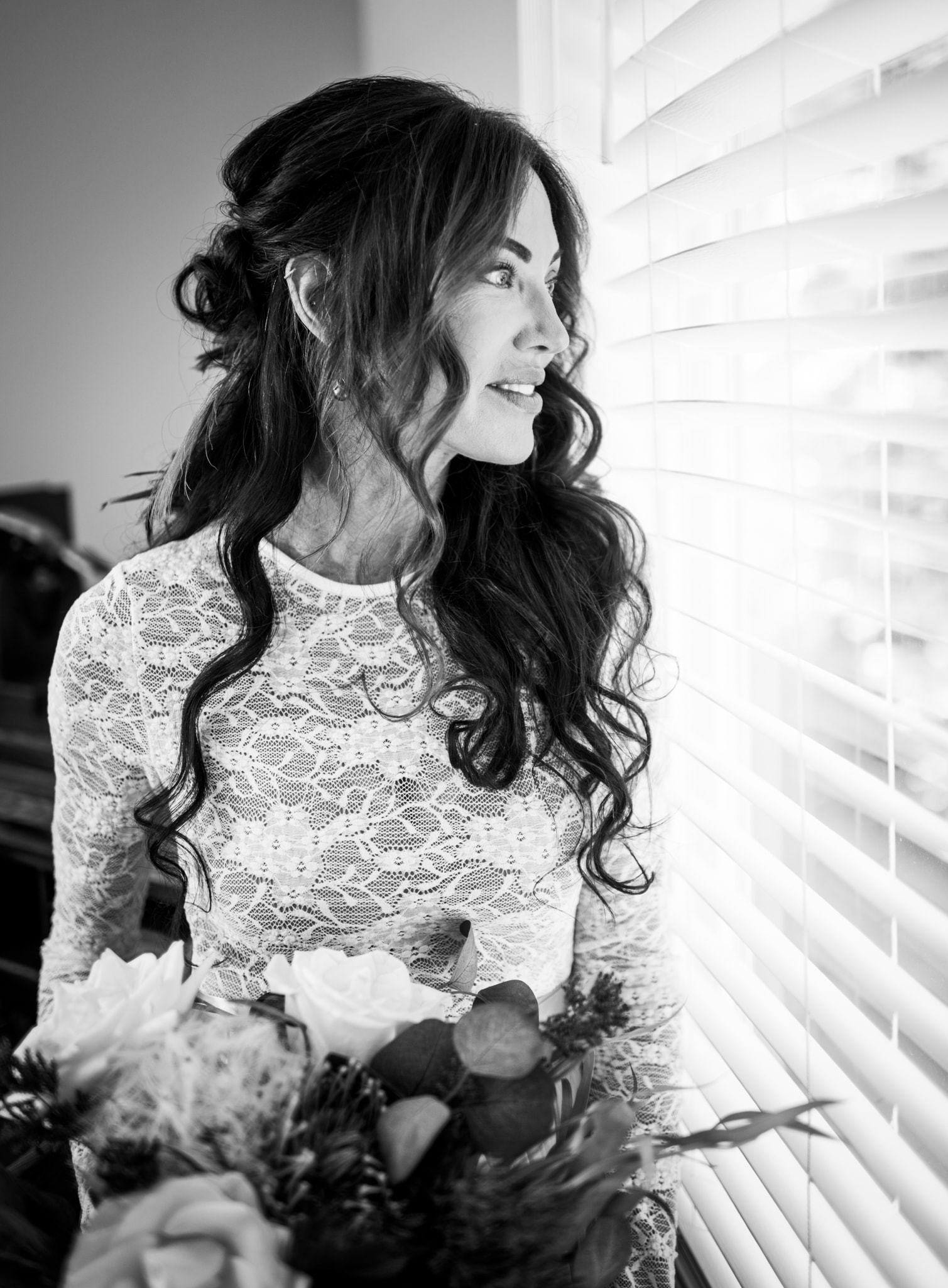 Woman in lace top by window blinds — senior portrait session Treasure Valley