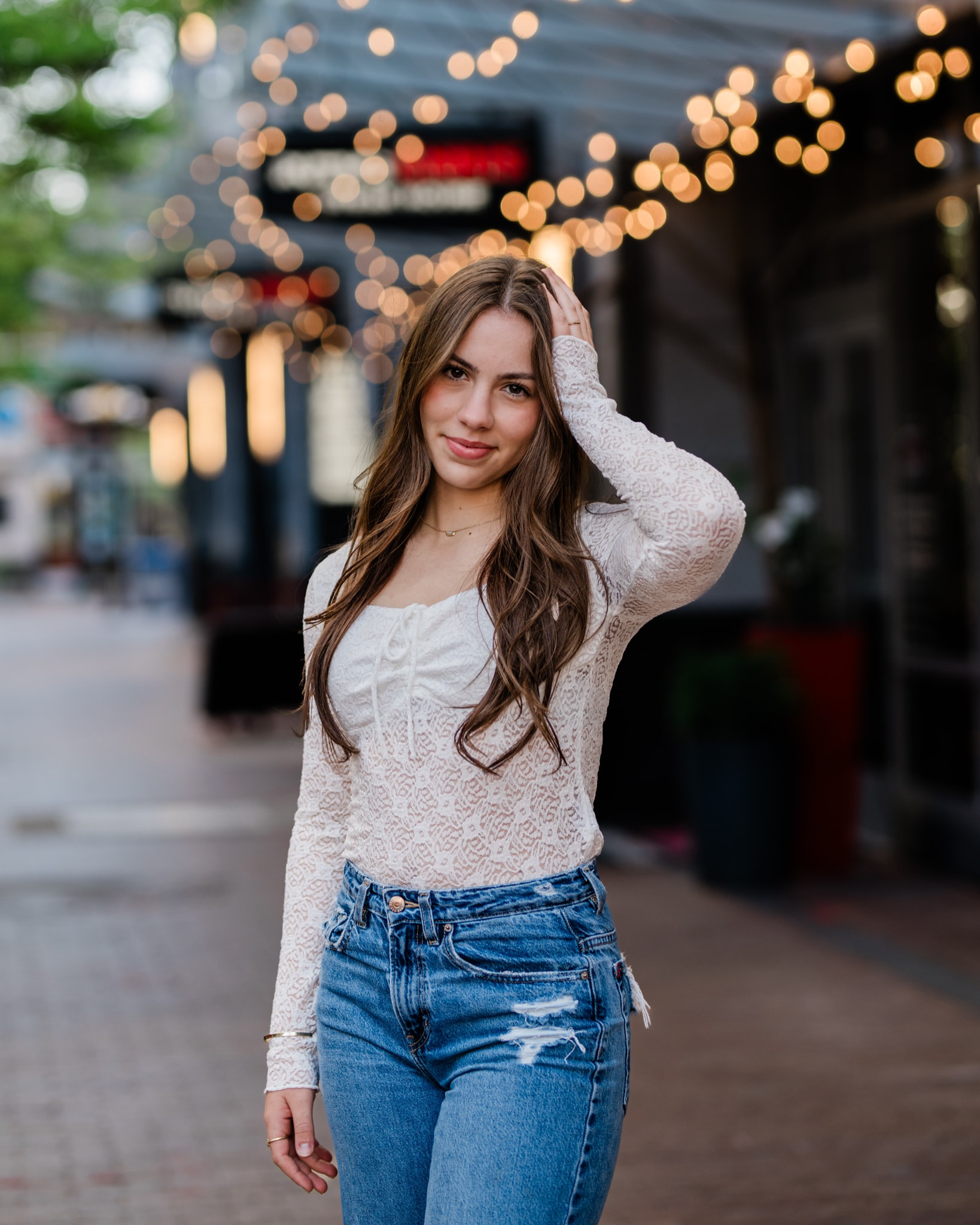 Senior girl posing on urban street with festive lights — Boise Idaho senior photography