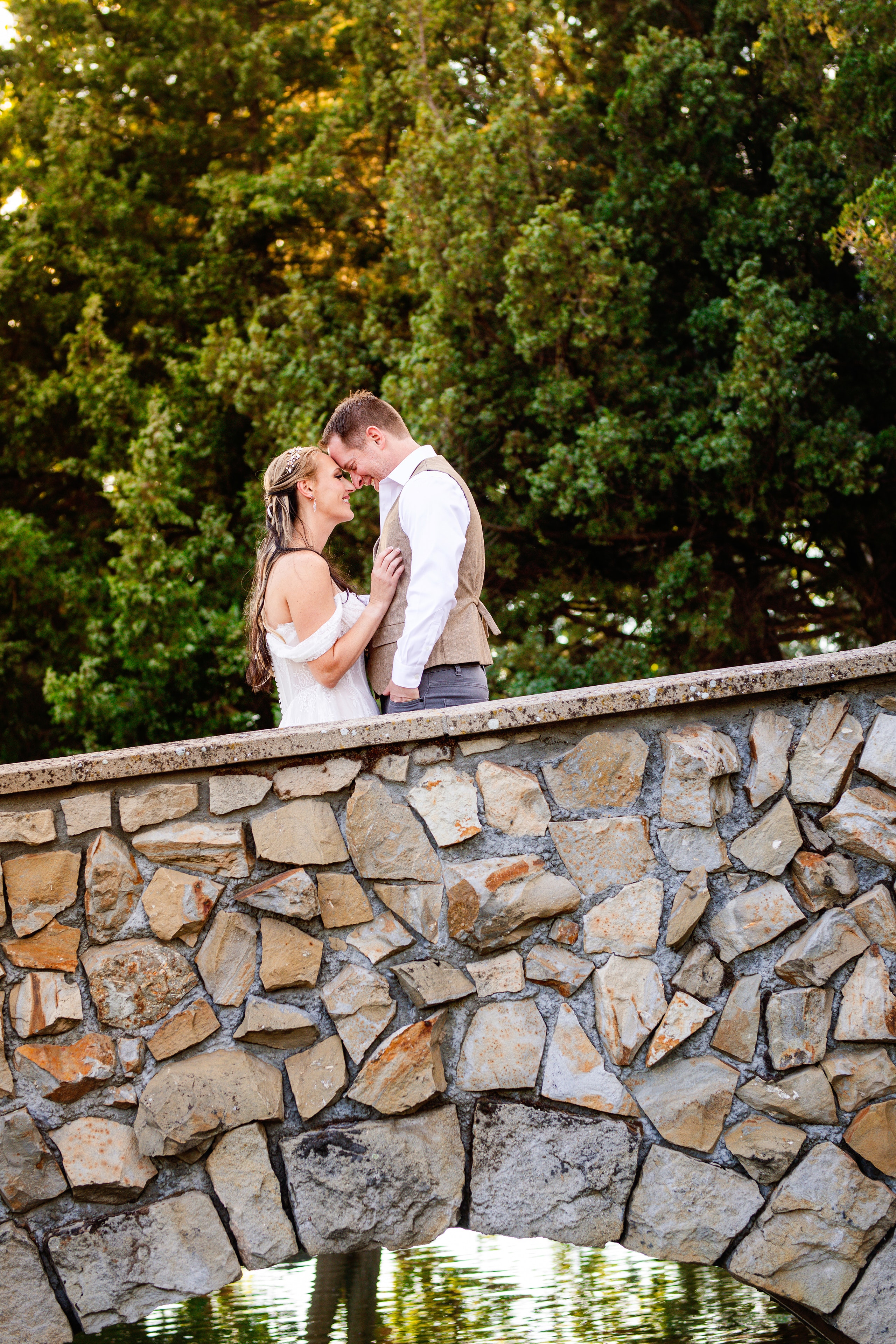Couple kissing on stone bridge outdoors — Chrissy Ray Photography