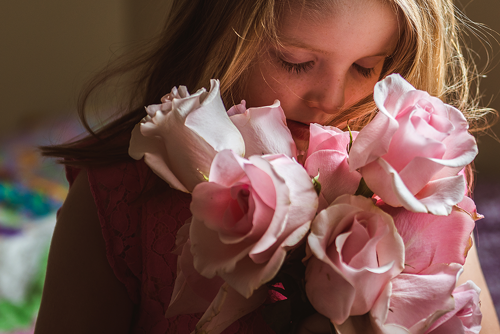 little girl holding pink roses